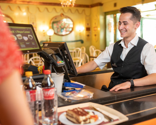 An employee at the cash register of a restaurant at Europa-Park.